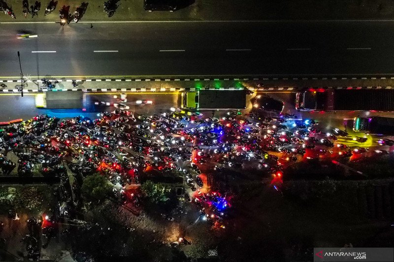 Foto udara pemudik sepeda motor terjebak kemacetan saat melintasi posko penyekatan mudik di jalur Pantura Patokbeusi, Subang, Jawa Barat, Selasa (11/5/2021) dini hari. Petugas gabungan memutar balik pemudik yang melintasi jalur pantura Subang pada H-2 jelang Hari Raya Idul Fitri 1442 H. ANTARA FOTO/M Ibnu Chazar/wsj. (ANTARA FOTO/Muhamad Ibnu Chazar)