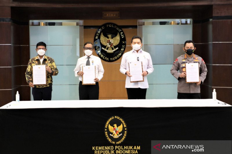 Menko Polhukam Mahfud MD bersama Menkominfo Johnny G Plate, Jaksa Agung ST Burhanuddin dan Kapolri Jenderal Pol Listyo Sigit Prabowo tengah memperlihatkan SKB Pedoman Implementasi UU ITE yang telah ditandatangani, di Kantor Kemenko Polhukam, Jakarta, Rabu (23/6/2021). (ANTARA/HO-Humas Kemenko Polhukam)