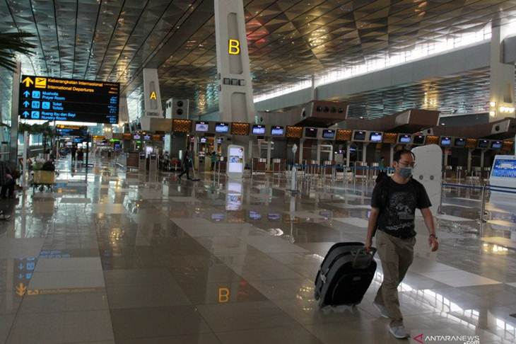 WNA calon penumpang melintas di area keberangkatan Internasional yang lengang di Terminal 3 Bandara Internasional Soekarno-Hatta, Tangerang, Banten, Rabu (1/4/2020). Kementerian Hukum dan HAM resmi melarang masuk dan transit bagi WNA yang akan berkunjung ke Indonesia. Larangan itu berlaku mulai 2 April 2020 hingga batas yang belum ditentukan untuk menekan penyebaran Covid-19. ANTARA FOTO/Muhammad Iqbal