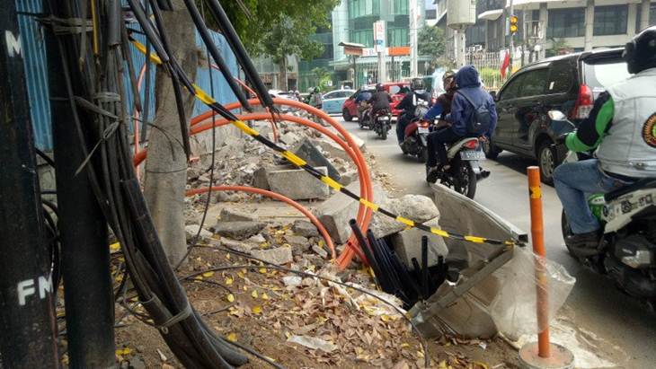Terpasang garis pembatas namun hanya seutas garis seoanjang satu meter di area pemasangan jaringan kabel bawah tanah yang terlihat semrawtmut dan menutupi jalur pejalan kaki di area Cikini antara Jalan Raden Saleh Raya dan Jalan Cikini Raya, Jakarta Pusat, Senin (4/10/2019). (ANTARA/Livia Kristianti)