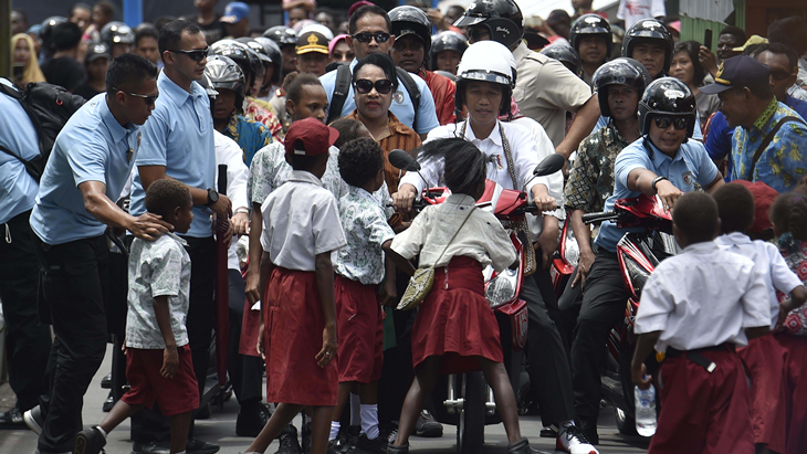 Presiden Joko Widodo berboncengan dengan Ibu Negara Iriana Joko Widodo menggunakan motor listrik menyapa warga saat kunjungan kerja di Distrik Agats, Kabupaten Asmat, Papua, Kamis (12/4). Kunjungan kerja Presiden ke Asmat diantaranya untuk pemberian gizi makanan tambahan bagi ibu hamil dan anak-anak, memeriksa pembangunan tampungan air hujan serta pembangunan rumah bagi warga Asmat. ANTARA FOTO/Puspa Perwitasari/ama/18