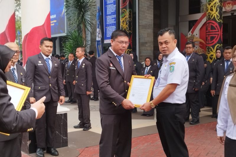 Plt. Kadisbunnak Kalbar, Rino Anteno Tengo (kanan) menyerahkan sertifikat dalam rangkaian Peringatan Hari Pengayoman ke-81 Tahun 2026, Rabu (19/8/2026) di Halaman Kantor Wilayah Kementerian Hukum Kalbar. ANTARA/Dedi