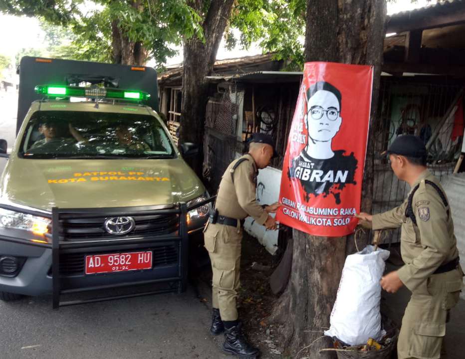 Satpol PP Solo, Jawa Tengah mencopoti spanduk dukungan bakal cawali dan cawawali di Pilwakot Solo, Achmad Purnomo-Teguh Prakosa, Jumat (27/12). (MP/Ismail) 