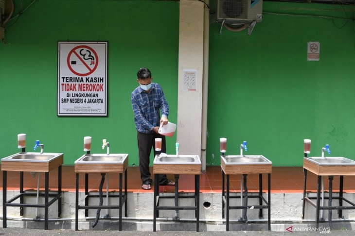 Karyawan mengisi ulang sabun cair di wastafel Sekolah Menengah Pertama (SMP) Negeri 4, Jakarta Pusat, Senin (22/3/2021). ANTARA FOTO/M Risyal Hidayat/rwa.