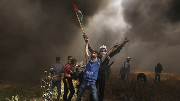 Pengunjuk rasa Palestina berteriak saat bentrok dengan pasukan Israel dalam sebuah protes menuntut hak kembali ke tanah air mereka, di perbatasan Israel-Gaza, timur Kota Gaza, Jumat (6/4). ANTARA FOTO/REUTERS/Mohammed Salem/cfo/18