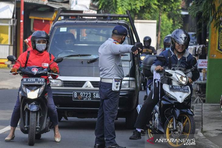 Petugas Dinas Perhubungan (Dishub) memberhentikan pengendara motor yang tidak memakai masker di Perbatasan Bekasi menuju Jakarta di Pondok Gede, Bekasi, Jawa Barat, Jum'at (10/4/2020). Pada operasi ini petugas mengawasi mobilitas kendaraan dari dan keluar wilayah Bekasi setelah adanya pembatasan Sosial Berskala Besar (PSBB) di DKI Jakarta. ANTARA FOTO/ Fakhri Hermansyah/aww.