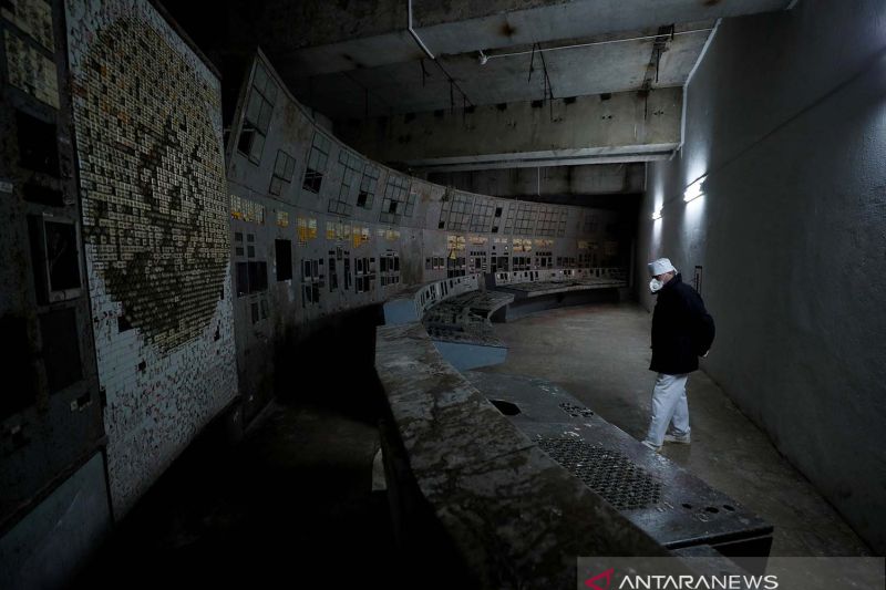 Seorang karyawan berjalan di pusat kendali reaktor keempat yang rusak di Pembangkit Listrik Tenaga Nuklir Chernobyl di Chernobyl, Ukraina, Kamis (25/3/2021). Gambar diambil pada (25/3/2021). REUTERS/Gleb Garanich/AWW/sa. (REUTERS/GLEB GARANICH)