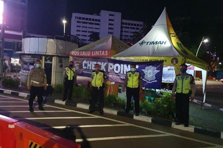 Petugas kepolisian di Check Point Tugu Tani Jakarta, Jumat (17/4/2020) malam, melakukan pengawasan penerapan pembatasan sosial berskala besar (PSBB). ANTARA/HO-Dok NTMC Polda Metro Jaya