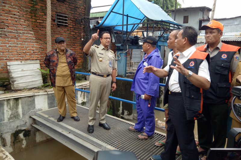 Anies mengecek alat pemilah sampah dan air yang akan melalui Pintu Air Karet di dekat Rumah Pompa Jati Pinggir 1, Karet Tengsin, Tanah Abang, Jakarta Pusat, Selasa (25/2/2020). (ANTARA/ Livia Kristianti)