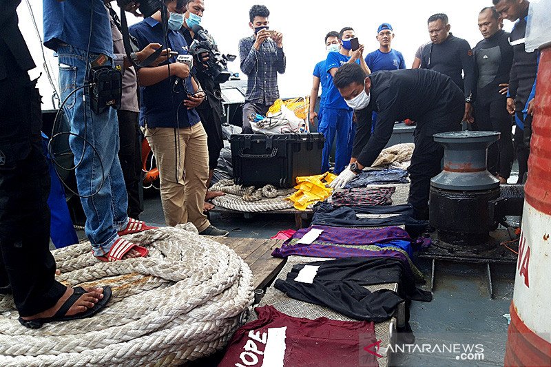 Petugas memeriksa sejumlah barang yang diduga milik penumpang dan pramugari pesawat Sriwijaya SJ-182 Air yang ditemukan di sekitar perairan Pulau Laki, Senin (11/1/2021). ANTARA/Muhammad Zulfikar/aa.