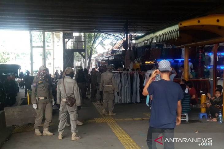Petugas Satpol PP Tanah Abang berpatroli membubarka kerumunan massa pedagang kaki lima di Pasar Tanah Abang, Jumat (27/3/2020). (ANTARA/Livia Kristianti)
