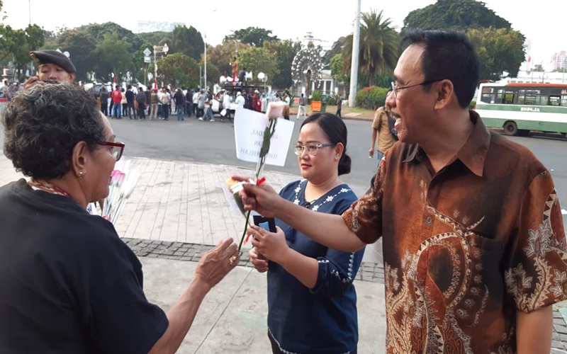 Massa AMPI membagikan bunga mawar kepada warga yang melintas