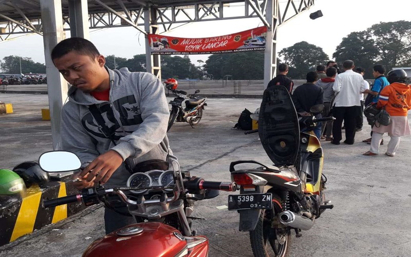 Petugas membantu membetulkan sepeda motor seorang peserta mudik gratis dari Jakarta