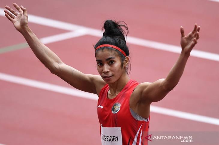 Sprinter Indonesia Alvin Tehupeiory melambaikan tangan usai memasuki garis finish dalam penyisihan 100 meter putri heat 3 cabang atletik Olimpiade Tokyo 2020 di Stadion Olimpiade Tokyo, Jepang, Jumat (30/7/2021). ANTARA FOTO/Sigid Kurniawan/rwa.
