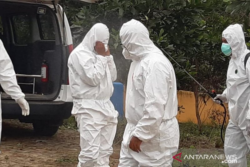 Nakes disemprot disinfektan setelah mengebumikan pasien COVID-19 di Tanjungpinang. ANTARA/ Nikolas Panama