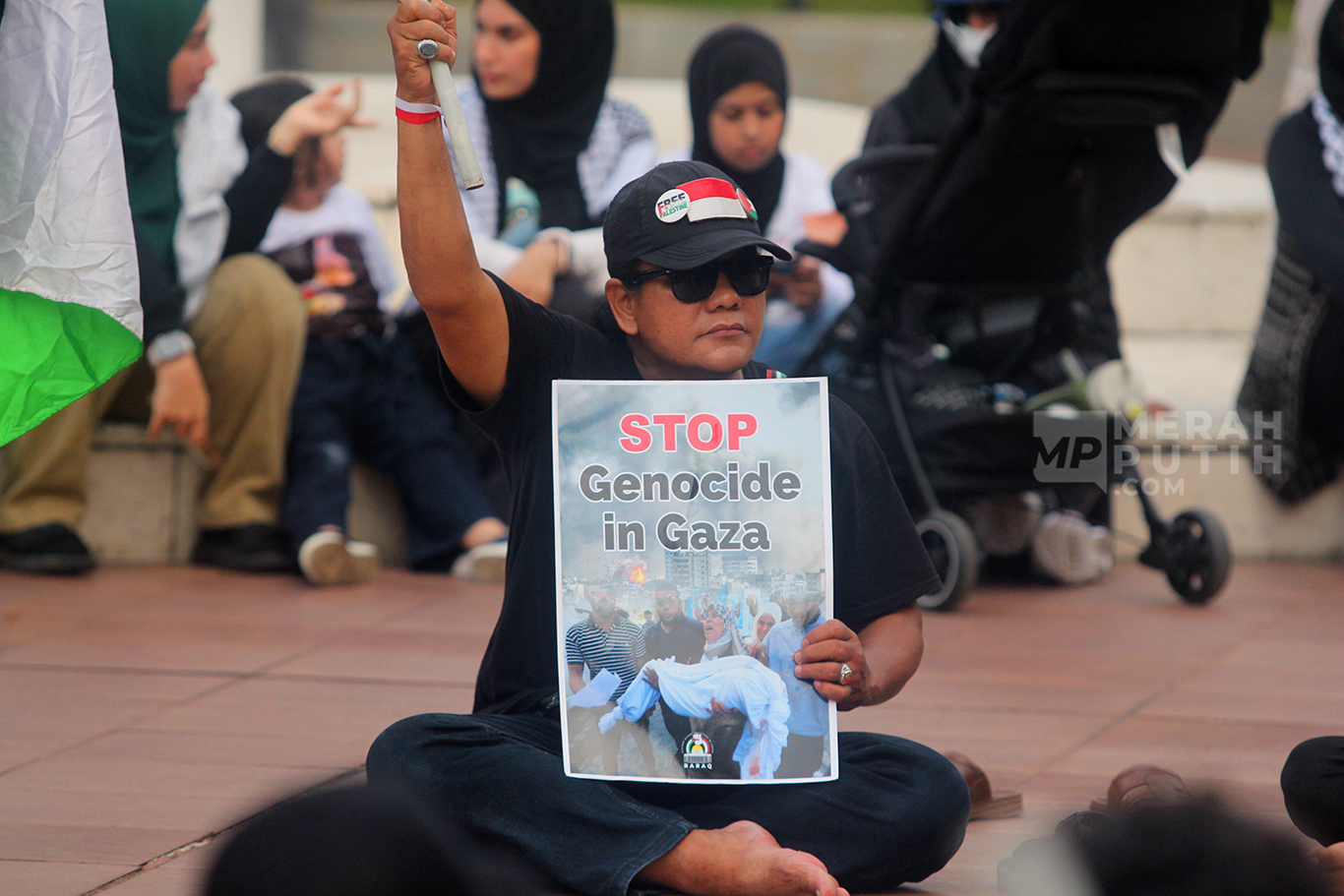 Aksi damai Bela Palestina dan Boikot Produk Israel membawa poster bertuliskan Stop Genocida di Tugu Proklamasi, Jakarta, Sabtu (15/6/2024).