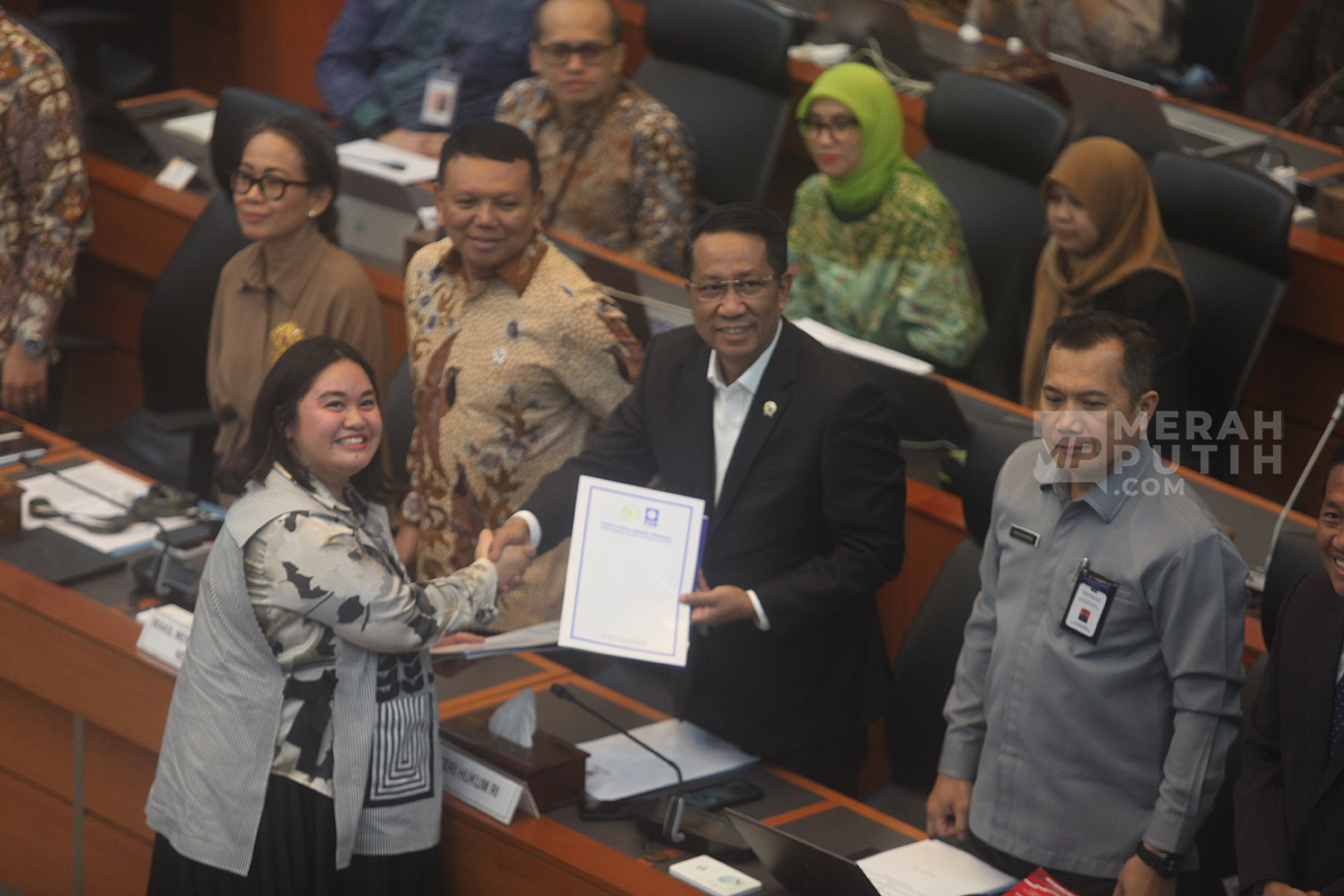 Perwakian Fraksi PAN Farah Putri Nahlia menyerahkan padangan mini fraksi kepada Menteri Hukum Supratman Andi Agtas saat rapat persetujuan tingkat I RUU TNI di Kompleks Parlemen, Senayan, Jakarta, Selasa (18/3/2025).
