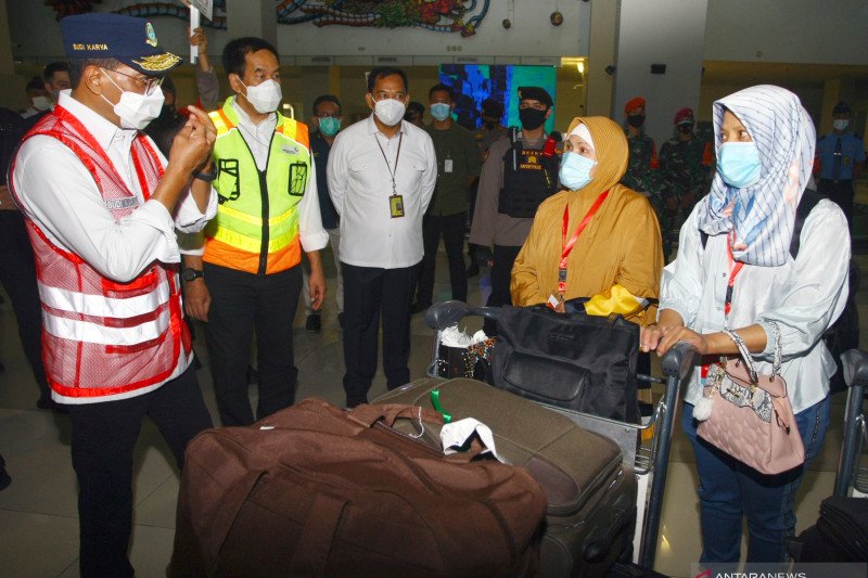 Menteri Perhubungan Budi Karya Sumadi (kiri) didampingi Direktur Utama PT Angkasa Pura II (Persero) Muhammad Awaluddin (kedua kiri) berbincang dengan Pekerja Migran Indonesia (PMI) yang baru saja mendarat di Terminal 3, Bandara Soekarno Hatta, Tangerang, Banten, Selasa (11/5/2021). ANTARA FOTO/Muhammad Iqbal.