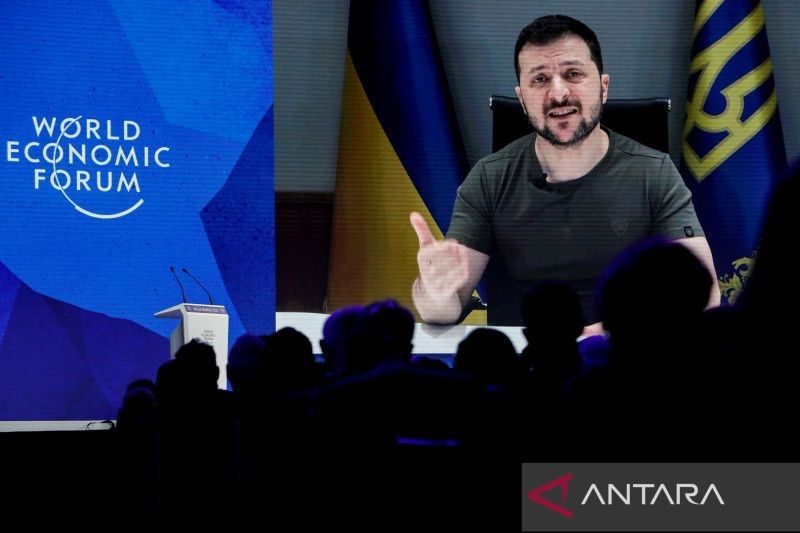 residen Ukraina Volodymyr Zelenskyy terlihat di layar saat menyampaikan pidato melalui video kepada delegasi Forum Ekonomi Dunia (WEF) di Davos, Swiss (23/5/2022). (Reuters/Arnd Wiegmann/wsj)