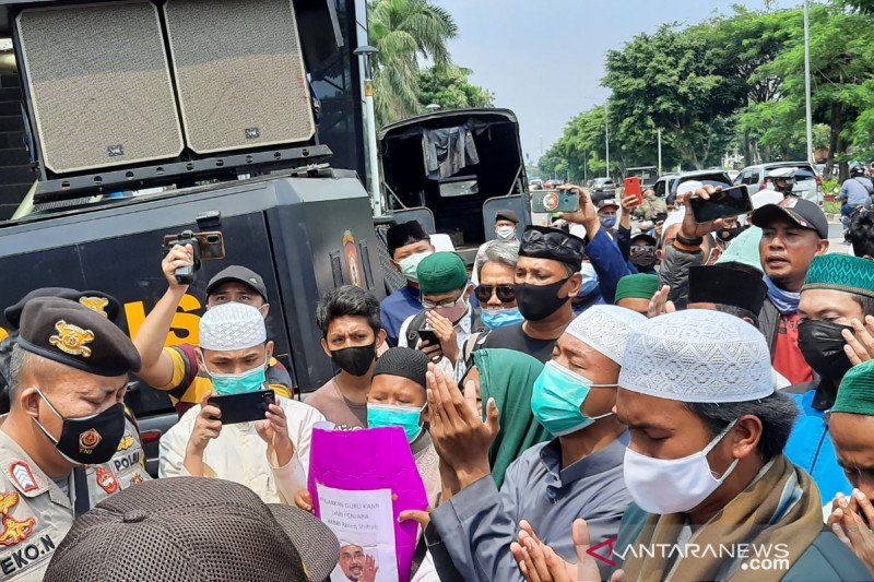 Polisi menghalau puluhan simpatisan Rizieq Shihab yang berupaya menggelar aksi di depan gedung Pengadilan Negeri Jakarta Timur, Jumat (26/3/2021). ANTARA/Yogi Rachman