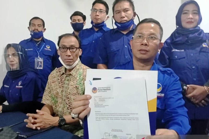 Ketua DPD Partai NasDem Surabaya Robert Simangunsong (duduk-kanan) didampingi sejumlah pengurus menujukkan surat rekomendasi untuk Azrul Ananda sebagai bakal calon wakil Machfud Arifin di Pilkada Surabaya 2020, Sabtu (25/07/2020). (ANTARA/ Hanif Nashrullah)