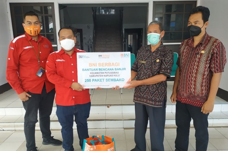 Pemimpin BNI Kantor Cabang Sintang Dwi Pramudita (kiri) menyerahkan bantuan secara simbolis kepada Asisten III Setda Kapuas Hulu Abdullah Sani (kanan) untuk korban banjir di wilayah Kapuas Hulu Kalimantan Barat. ANTARA FOTO/HP-Teofilusianto Timotius