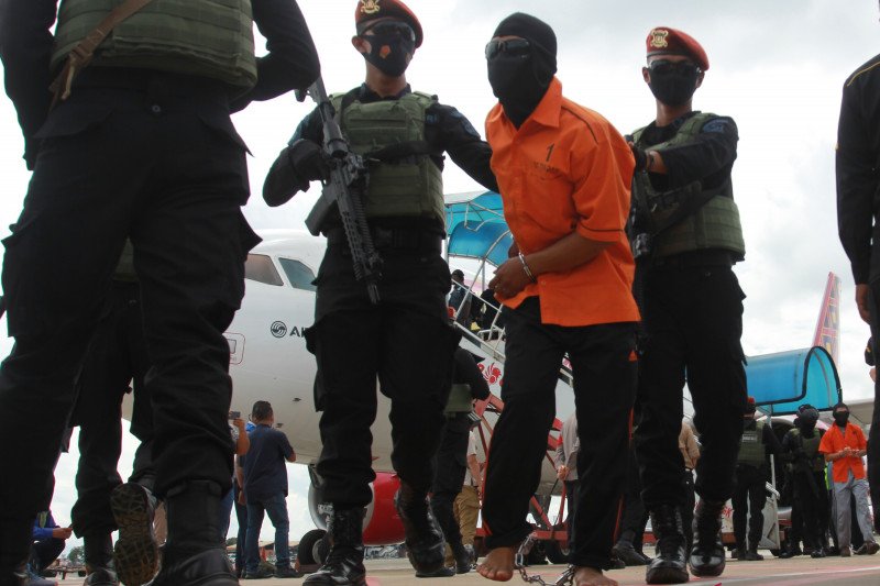 Petugas Detasemen Khusus (Densus) 88 membawa terduga teroris dari Lampung setibanya di Bandara Soekarno Hatta, Tangerang, Banten, Rabu (16/12/2020). ANTARA FOTO/Muhammad Iqbal/foc. (ANTARA FOTO/MUHAMMAD IQBAL)