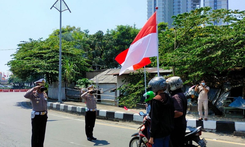  Penghormatan kepada bendera merah putih yang dilakukan petuhas kepolisian dan para pengendara yang melintasj Jl. A. Yani Surabaya pada pukul 10.17, Selasa (17/08/2021). (MP/Andika Eldon)