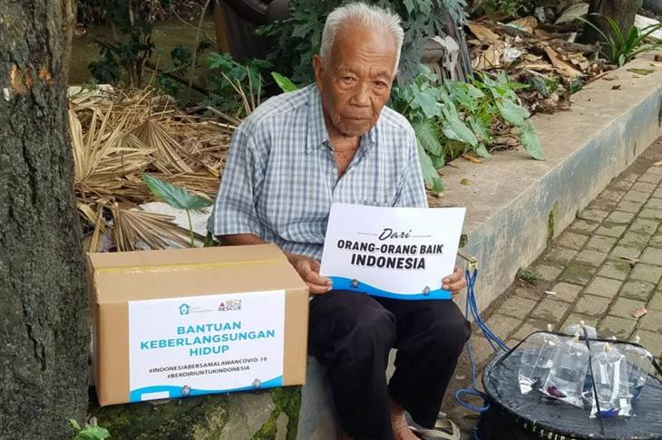 Seorang pedagang Ikan Cupang keliling menerima paket Bantuan Keberlangsungan Hidup dari Sekolah Relawan, Depok, Jawa Barat, Selasa (24/3/2020) (ANTARA/HO-Sekolah Relawan)