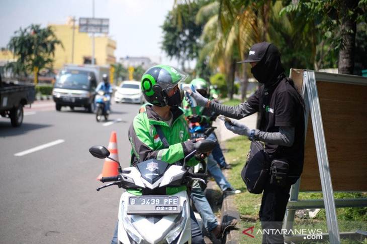 Petugas "Posko Aman Bersama Gojek" sedang memeriksa suhu tubuh mitra pengemudi di salah satu titik poin cek, di Jakarta, Rabu (22/04/2020) (ANTARA/Ho-Gojek)