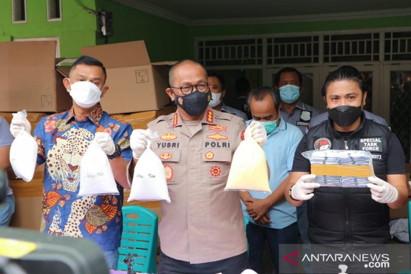 Kabid Humas Polda Metro Jaya Kombes Pol Yusri Yunus (tengah) perlihatkan barang bukti kasus pembuatan kosmetik ilegal dalam jumpa pers di lokasi penggerebekan pabrik kosmetik ilegal di Jatiasih, Kota Bekasi, Jawa Barat, Jumat (29/1/2021). ANTARA/Fianda Sjofjan Rassat