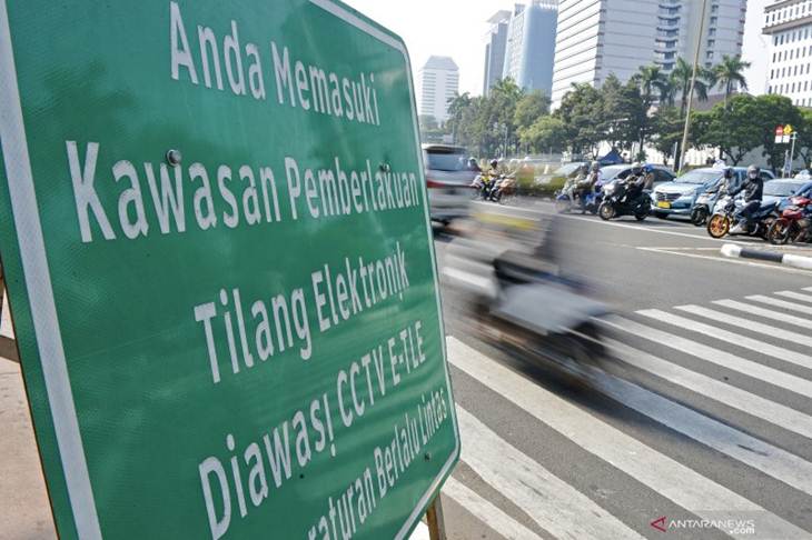 Pengendara melintas di dekat rambu tilang elektronik di kawasan Jalan Medan Merdeka Barat, Jakarta, Senin (1/7/2019). Direktorat Lalu Lintas Polda Metro Jaya menerapkan penilangan dengan sistem Electronic Traffic Law Enforcement (ETLE) dengan memasang 10 kamera baru dengan fitur tambahan yang dapat mendeteksi pemakaian sabuk pengaman, penggunaan telepon genggam oleh pengemudi, nomor pelat ganjil genap dan batas kecepatan pengemudi. ANTARA FOTO/Nova Wahyudi/foc.