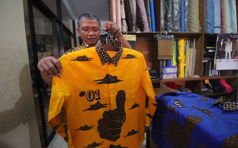 Suparto menunjukan batik dengan motif salam jempol yang dipesan keluarga Jokowi