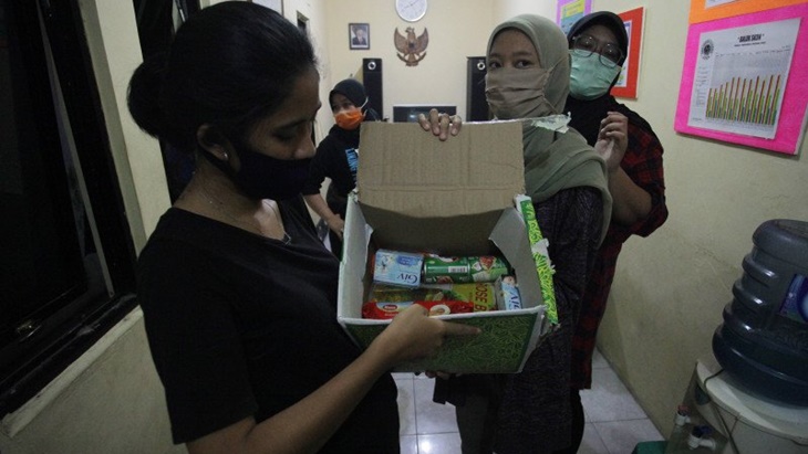 Warga DKI menunjukan paket sembako yang diberikan Pemprov DKI terkait bansos corona