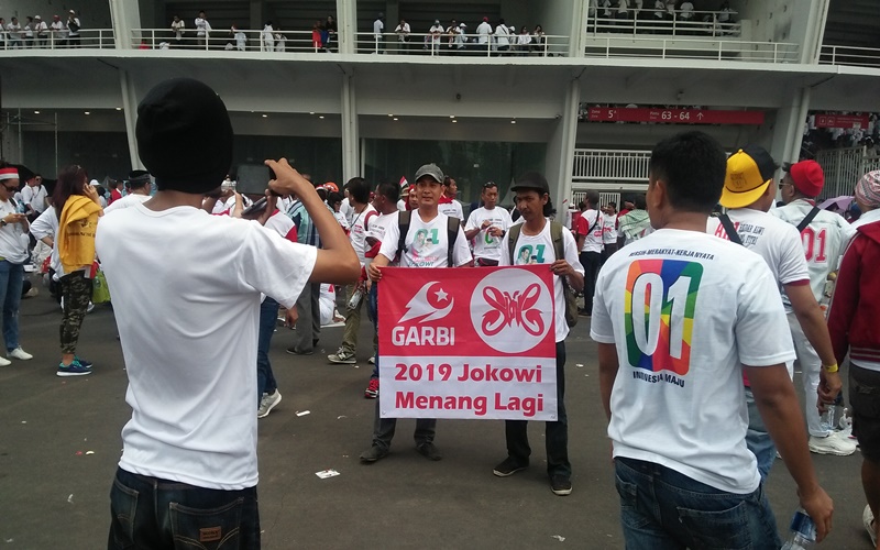 Dua orang membentang bendera GARBI dengan tulisan Jokowi Menang 2019