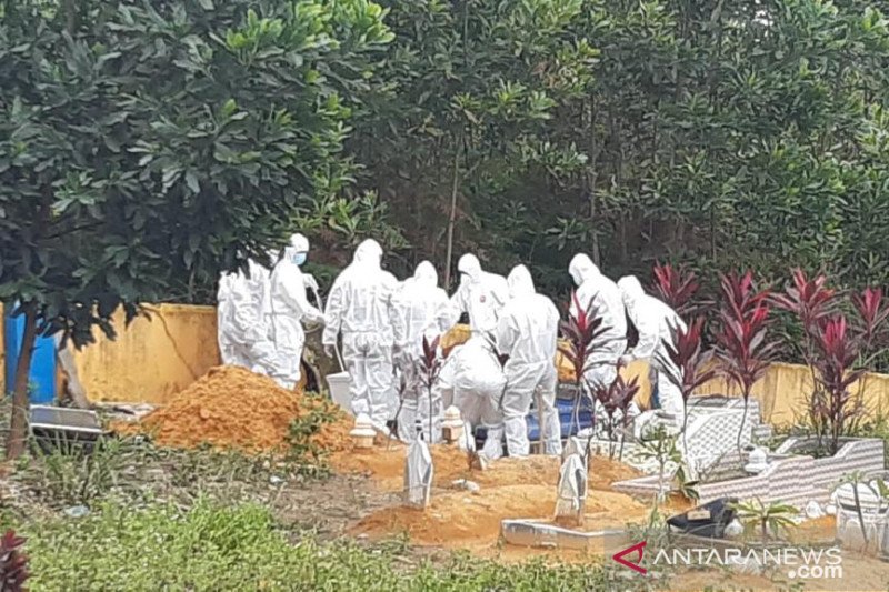 Petugas mengebumikan pasien COVID-19 di Kelurahan Kawal, Kabupaten Bintan, Provinsi Kepulauan Riau. (FOTO ANTARA/Nikolas Panama)
