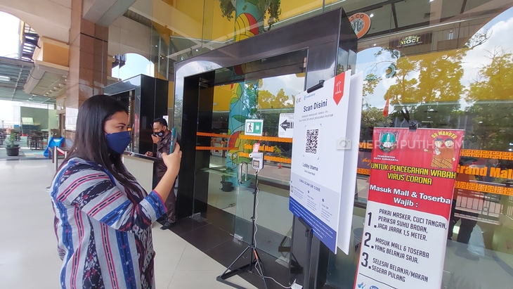 Pengunjung memanfaatkan aplikasi PeduliLindungi saat masuk ke Solo Grand Mal. (MP/Ismail)