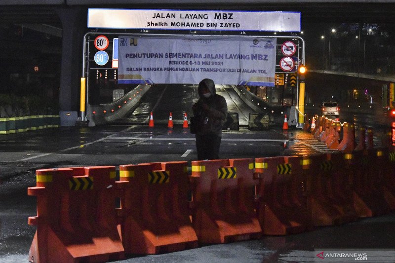 Seorang jurnalis melakukan peliputan di sekitar Tol Layang MBZ (Mohamed Bin Zayed) yang ditutup sementara di Bekasi, Jawa Barat, Kamis (6/5/2021) dini hari. Penutupan sementara Tol Layang MBZ saat masa larangan mudik 6-18 Mei tersebut untuk membatasi pergerakan masyarakat guna memutus rantai penyebaran COVID-19. ANTARA FOTO/ Fakhri Hermansyah/wsj.