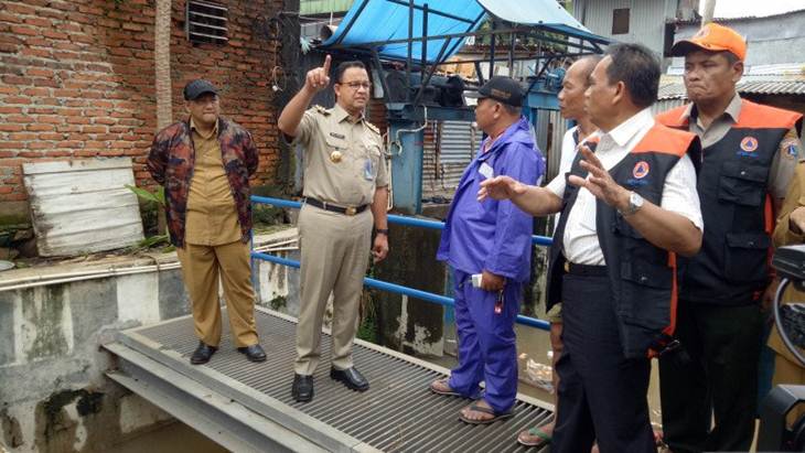 Anies mengecek alat pemilah sampah dan air yang akan melalui Pintu Air Karet di dekat Rumah Pompa Jati Pinggir 1. (ANTARA/ Livia Kristianti)