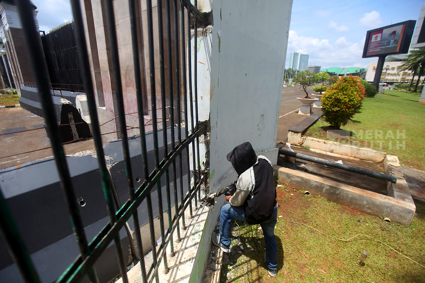 Pekerja memperbaiki pagar depan Kompleks Parlemen yang roboh di Gedung DPR, Senayan, Jakarta, Jumat (21/3/2025).