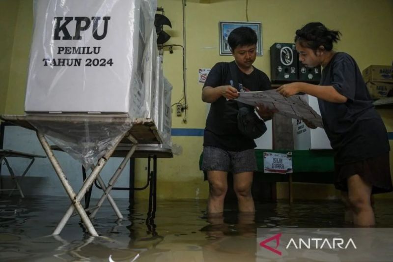 Dua petugas memeriksa surat suara di TPS 039 karena banjir di Duri Kepa, Kebon Jeruk, Jakarta, Rabu (14/2). Foto: ANTARA/Sulthony Hasanuddin