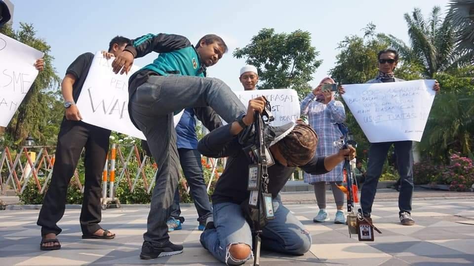 Adegan teatrikal jurnalis se-Surabaya bentuk protes kekerasan terhadap wartawan Tempo, Nurhadi oleh oknum aparat keamanan di depan Gedung Grahadi, Surabaya, Senin (29/3). Foto: MP/Budi Lentera