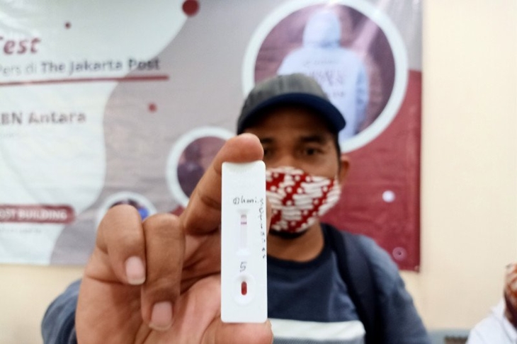 Fotografer The Jakarta Post Doni Setiawan memperlihatkan alat rapid test di lobi gedung perusahaan Jalan Palmerah Barat, Tanah Abang, Jakarta Pusat, Selasa (7/7/2020). (ANTARA/Andi Firdaus).