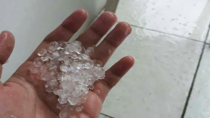 Warga menunjukan es yang jatuh bersama hujan