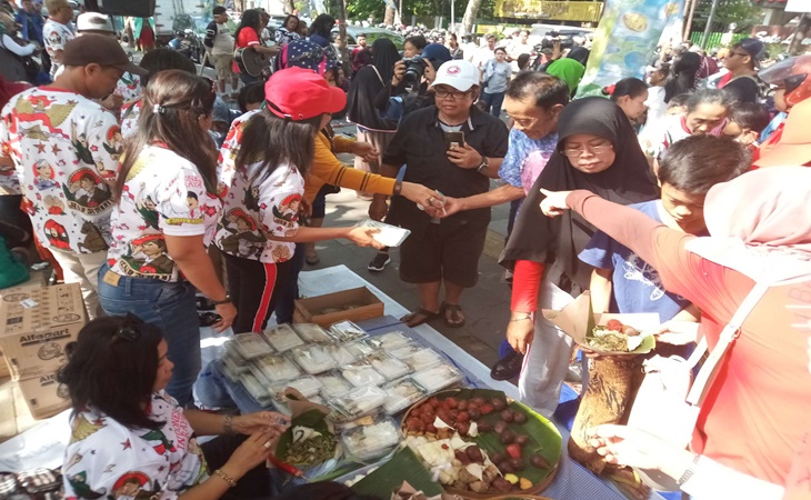 Relawan Gibran yang tergabung dalam Kagege membagikan tumpeng kepada warga di CFD Solo