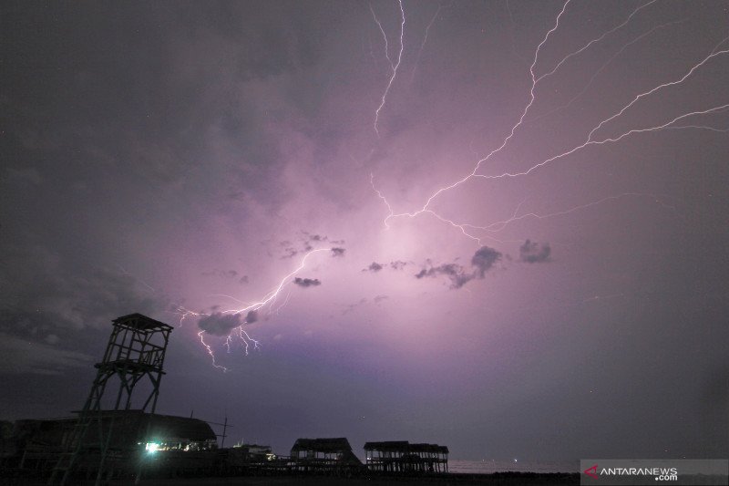 Petir terlihat di kawasan pesisir Indramayu, Jawa Barat, Senin (14/12/2020). Badan Meteorologi, Klimatologi dan Geofisika (BMKG) memperkirakan gelombang disertai hujan dan petir masih akan terjadi di laut Jawa. ANTARA FOTO/Dedhez Anggara/wsj.