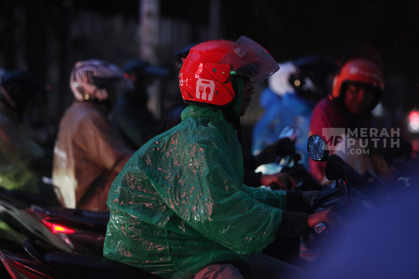 Pengendara motor memakai jas hujan saat  hujan deras mengguyur kawasan Kebayoran Baru, Jakarta Selatan, Selasa (30/9/2025).