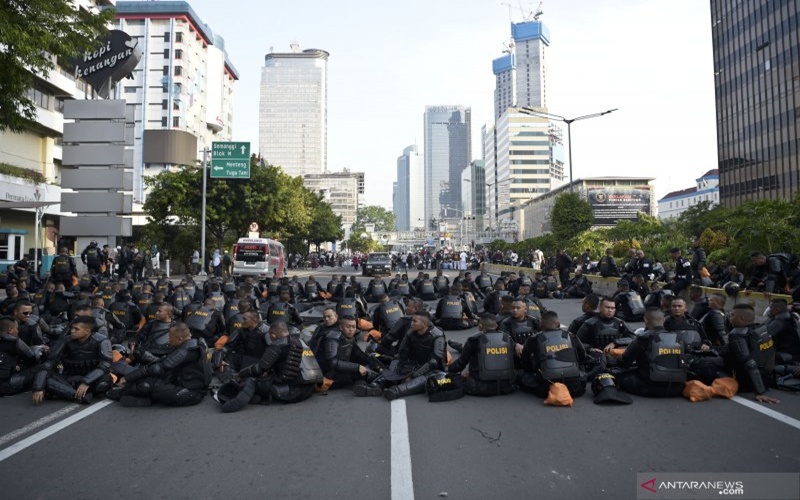 Petugas kepolisian yang mengawal massa yang berunjuk rasa depan Bawaslu