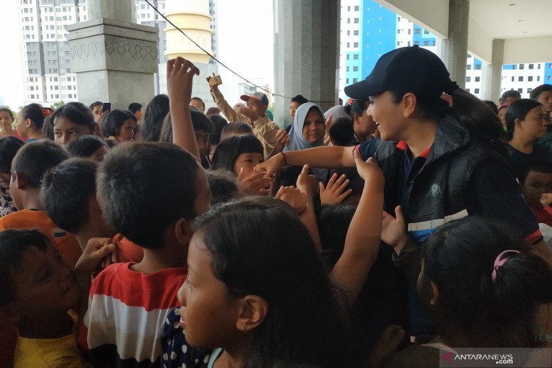 Istri Menteri Sosial yang juga penasihat Dharma Wanita Kementerian Sosial Grace Juliari Batubara (bertopi) bersalaman dengan anak-anak di pengungsian di Masjid Raya KH Hasyim Asy'ari di Rawa Buaya Jakarta Barat, Sabtu (4/1/2020). (FOTO ANTARA/Desi Purnamawati)