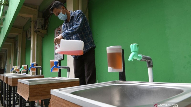 Karyawan mengisi ulang sabun cair di wastafel Sekolah Menengah Pertama (SMP) Negeri 4, Jakarta Pusat, Senin (22/3/2021). (ANTARA FOTO/M RISYAL HIDAYAT)